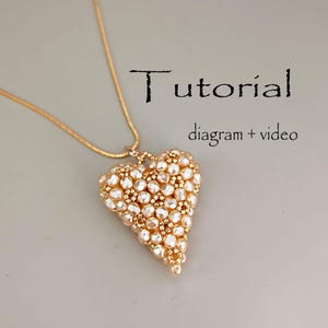 May include: A gold-colored necklace with a heart-shaped pendant. The pendant is made of small, light-colored beads and gold-colored beads. The word "Tutorial" and the phrase "diagram + video" are written on the image.