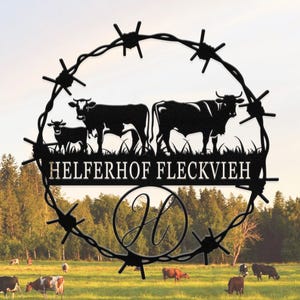 May include: Black metal silhouette of cows with barbed wire design and the text "Helferhof Fleckvieh" and a letter "H" in a circle. The silhouette is against a backdrop of a green field and a blue sky.