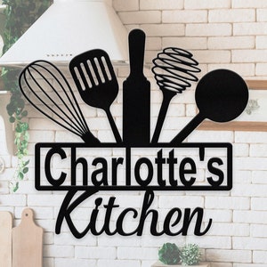 Könnte beinhalten: Schwarzes Küchen-Schild aus Metall mit einer Silhouette von Küchenutensilien und dem Text "Charlotte's Kitchen".