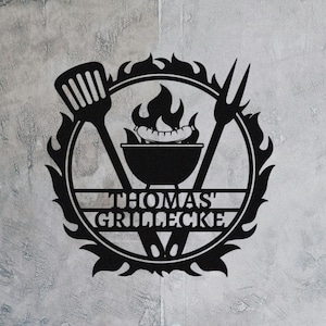 Könnte beinhalten: Schwarze Wandkunst aus Metall mit Grill, Spatel und Zange mit Flammen und dem Text "Thomas' Grillecke".
