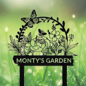 Puede incluir: Letrero de jardín de metal negro con una mariposa, flores y hojas. El letrero dice "Monty's Garden".