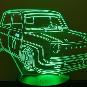 Può includere: Un contorno verde neon di un'auto d'epoca con la scritta "SIMCA" sul davanti. L'auto ha il numero "77" sul lato.