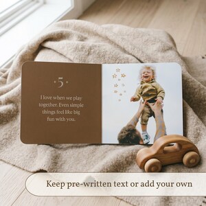 Peut inclure: Un livre photo personnalis&eacute; ouvert sur une page au fond marron avec le texte +5 I love when we play together. Even simple things feel like big fun with you. La page oppos&eacute;e montre une photo d'un enfant soulev&eacute; dans les airs.