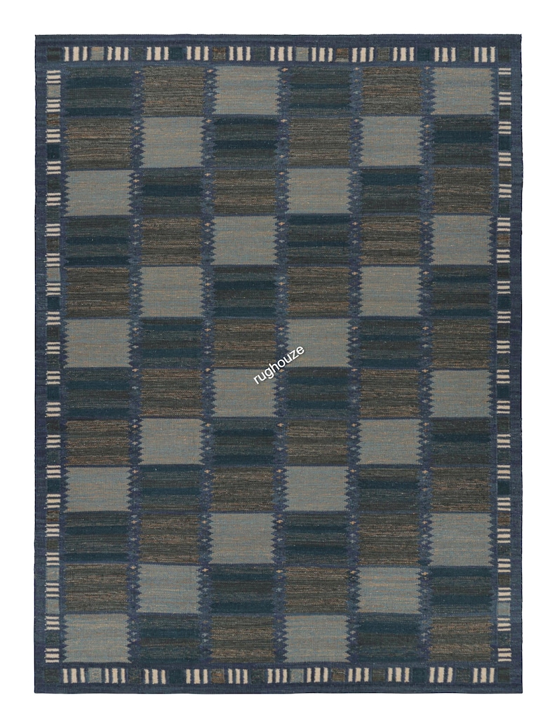 Puede incluir: Alfombra rectangular con un dise&ntilde;o a cuadros en tonos azules, grises y marrones. La alfombra tiene un borde azul oscuro con un patr&oacute;n repetitivo de rect&aacute;ngulos blancos y azules. La palabra "rughouze" es visible en el centro de la alfombra.