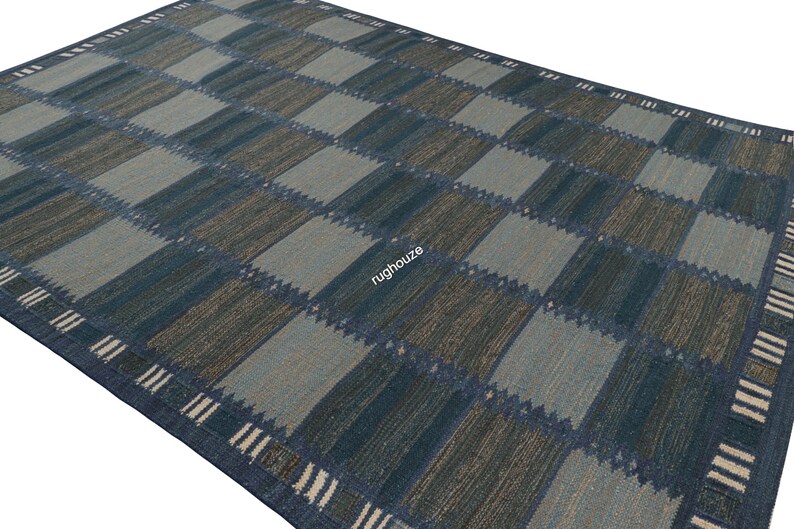 Puede incluir: Una alfombra rectangular grande con un patr&oacute;n de cuadros en tonos de azul, gris y marr&oacute;n. El dise&ntilde;o presenta cuadrados alternos de diferentes tonos, creando un efecto geom&eacute;trico. El borde tiene un patr&oacute;n de rayas en blanco y azul.