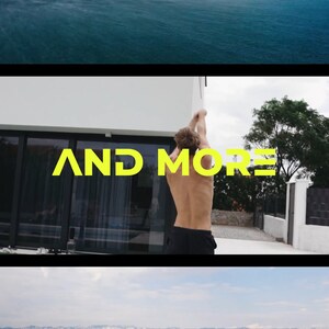 May include: A man stands in front of a white building with a pool in the background. The text "AND MORE" is written in yellow letters on the building. The man is wearing black shorts and has his back to the camera.
