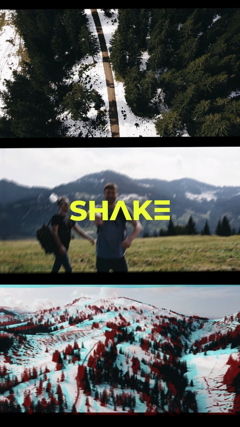 May include: Two people walking in a grassy field with mountains in the background. The word "SHAKE" is written in yellow letters across the image.