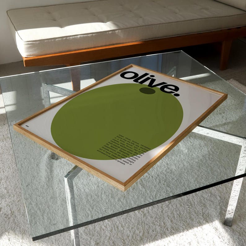May include: A framed print featuring a large green circle and the word "olive." in black text. The print has a white background and a wooden frame.