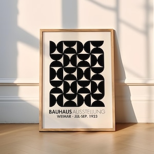 Bauhaus Exhibition inspired Poster 1923 with black text with the words “BAUHAUS AUSSTELLUNG WEIMAR JUL – SEP 1923” on a beige background. Features a Bauhaus inspired black geometric illustration.