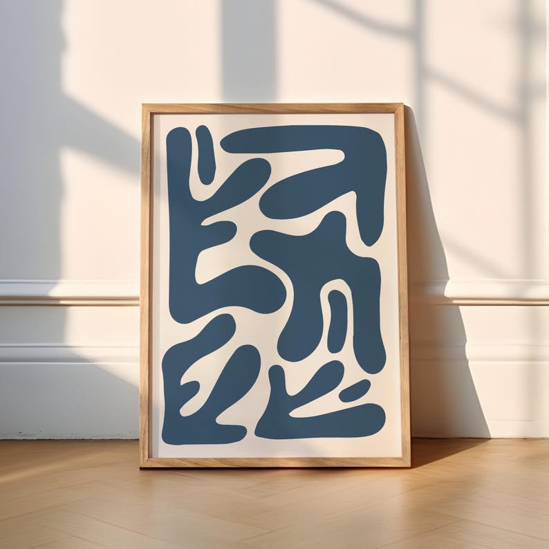 May include: A framed abstract print with a blue and white color scheme. The print features a pattern of organic shapes in a dark blue color against a white background.