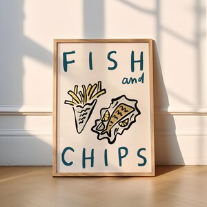 May include: A framed print with the words "FISH and CHIPS" in teal lettering. The image features a cartoon illustration of a cone of french fries and a wrapped fish, both outlined in black with yellow and orange accents.