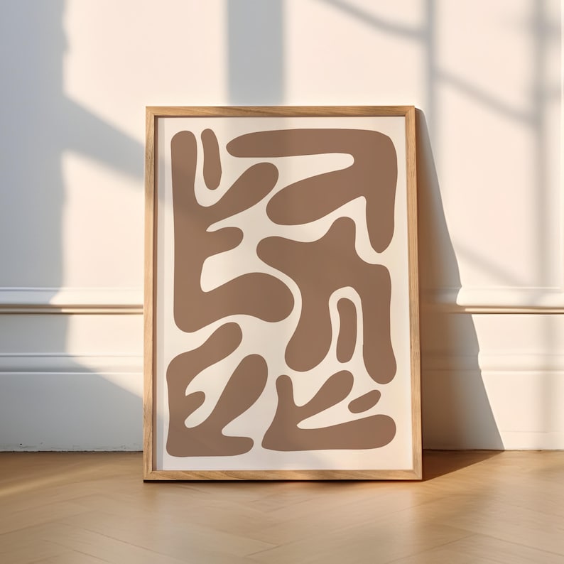 May include: A framed abstract print with a brown and white color scheme. The print features a pattern of organic shapes.