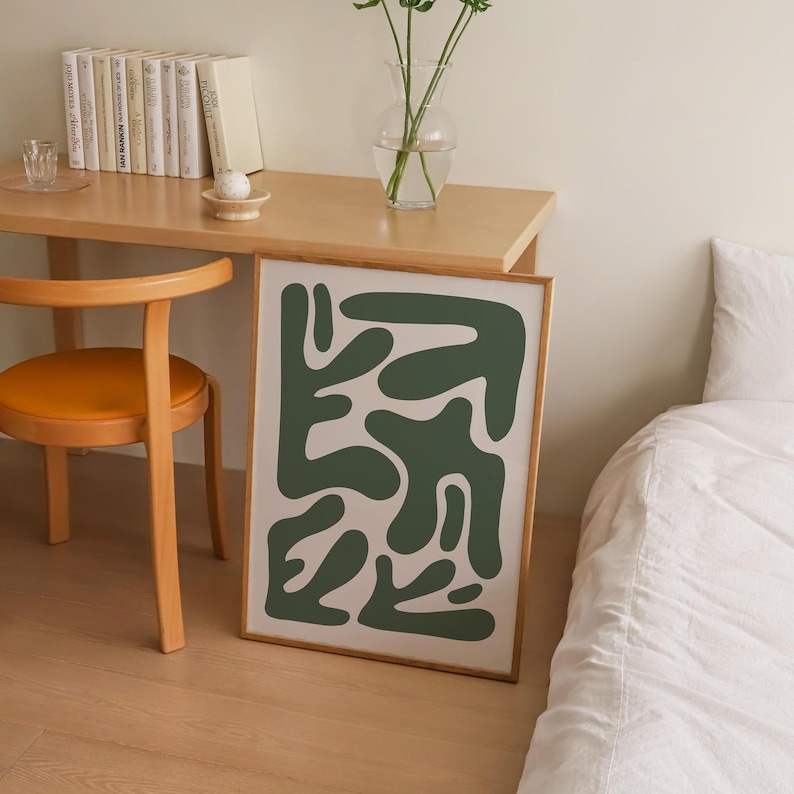 May include: A framed abstract print with a green and white design. The print features a series of organic shapes in a dark green color on a white background.