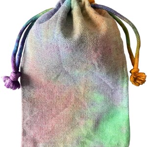 May include: A tie-dye drawstring bag in pastel shades. The bag is made from a textured material and has a drawstring closure with multi-coloured cords. The colours include pink, green, yellow, and purple.