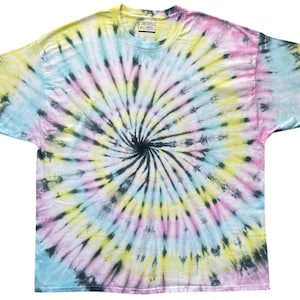 Puede incluir: Una camiseta de manga corta con cuello redondo que presenta un patrón de teñido anudado en espiral en tonos pastel amarillo, azul claro y rosa suave, con un punto central negro oscuro que irradia hacia afuera por toda la tela de la prenda.