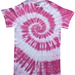 Puede incluir: Una camiseta de manga corta con cuello redondo que presenta un vibrante patrón de teñido anudado en espiral de color rosa y blanco. El diseño irradia desde el centro del pecho hacia afuera en un movimiento circular. Una etiqueta blanca es visible.