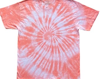 May include: A short-sleeved crew neck t-shirt featuring a spiral tie-dye pattern in shades of coral orange and white. The garment has a standard fit with a round neckline and a visible interior label at the collar area, displaying a consistent colour scheme.