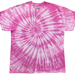 May include: A short-sleeved crew neck t-shirt featuring a vibrant pink and white spiral tie-dye pattern. The garment has a standard fit with a round neckline and short sleeves. A small interior label at the neck displays the size XL and brand text.
