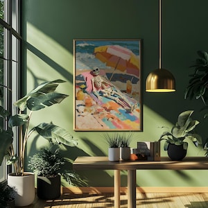 May include: A framed painting depicts a skeleton relaxing on a beach under a colorful umbrella. The artwork features vibrant colors and a whimsical theme, with the skeleton sunbathing on a towel. The painting is displayed on a green wall.