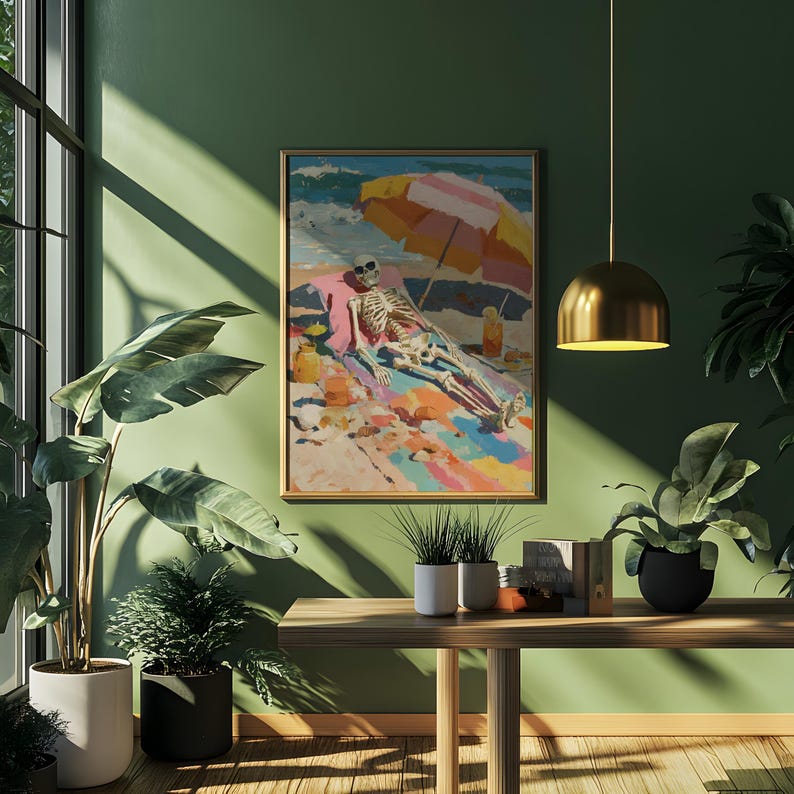 May include: A framed painting depicts a skeleton relaxing on a beach under a colorful umbrella. The artwork features vibrant colors and a whimsical theme, with the skeleton sunbathing on a towel. The painting is displayed on a green wall.