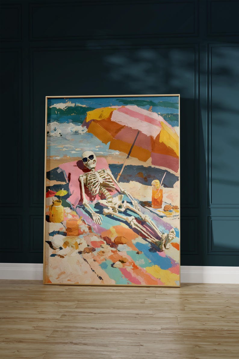 May include: A framed art print depicts a skeleton relaxing on a beach. The skeleton wears sunglasses and is under a striped umbrella. A colorful beach scene with a drink and small umbrellas is also visible.