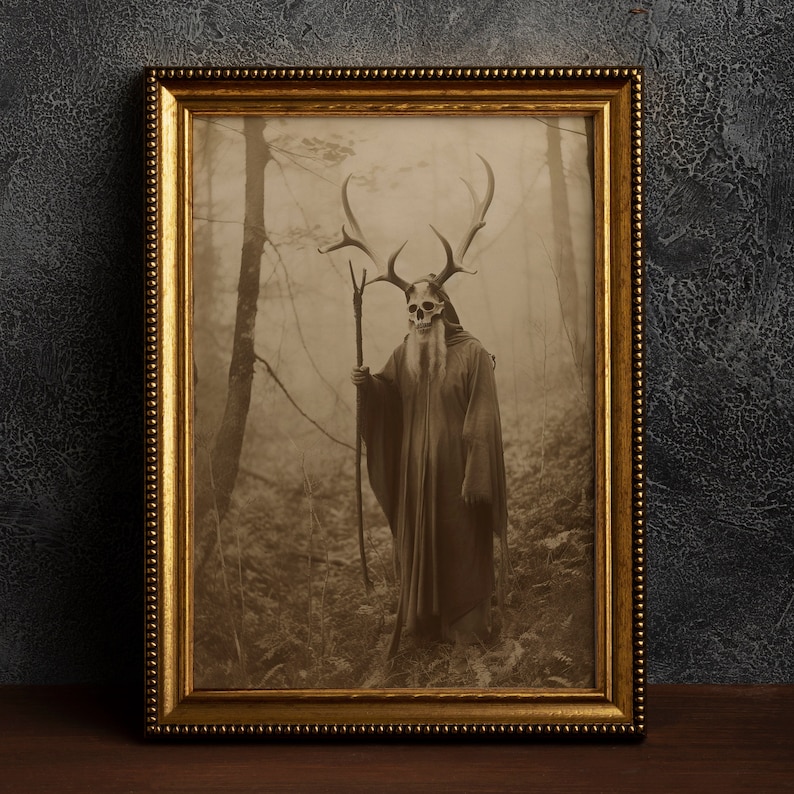 May include: Sepia-toned framed print featuring a figure in a forest. The figure wears a skull mask with antlers, a long beard, and a flowing robe, holding a staff. The gold frame has a beaded edge.