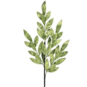 May include: A single artificial plant stem with multiple green leaves. The leaves have a glittery texture and are arranged along a dark stem. The plant is set against a white background, highlighting its details.