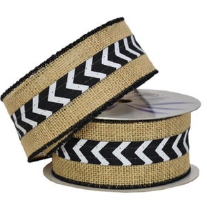 May include: A roll of burlap ribbon with a black and white chevron pattern. The ribbon has a natural tan color with a black stitched edge. The chevron pattern is black and white.