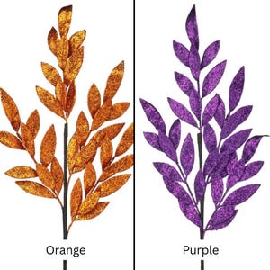 May include: Two decorative artificial branches featuring pointed leaves covered in glitter. One branch is orange and the other is purple. Each branch has a central stem and multiple smaller stems extending outward, with the text Orange and Purple below.