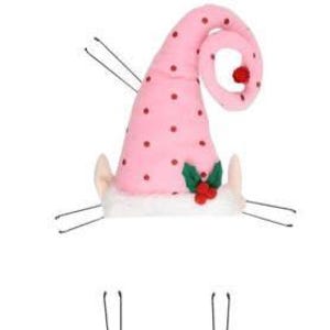 May include: A pink elf hat with red polka dots and a curled top. The hat features a white trim, small beige ears, and a sprig of holly with red berries. The hat is secured with bobby pins.