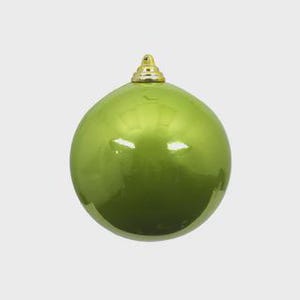 May include: A shiny, lime green Christmas ornament with a gold-colored cap. The round ornament reflects light, creating highlights on its surface. The ornament is a festive decoration for the holiday season.