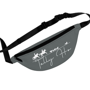 May include: Gray fanny pack with a black adjustable strap and buckle. The pack features a white graphic of riders on horses and dogs, with the words "Tally Ho" in a cursive font.