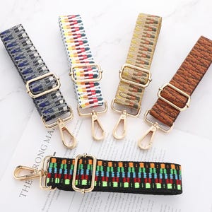 May include: A selection of patterned bag straps with gold-coloured metalwork. The straps display diverse designs in blue, red, yellow, and brown. The straps are arranged on a white surface with text.