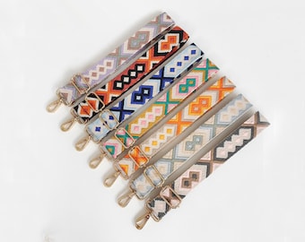 May include: Set of seven colorful patterned fabric straps with gold metal clasps. The straps have a geometric design with various colors including blue, orange, pink, and green.