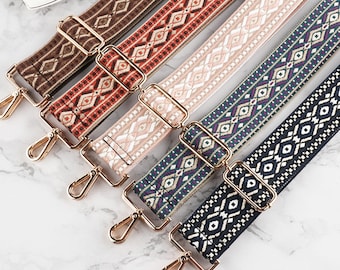 May include: A collection of colorful, patterned bag straps. Each strap features a unique geometric design in shades of brown, red, pink, green, and black. Gold-colored metal hardware is attached to each strap.