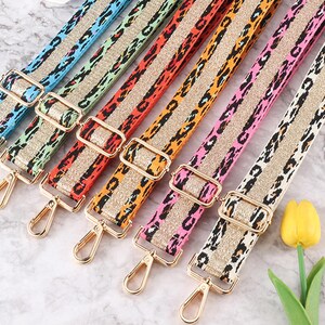 May include: Set of seven colorful adjustable straps with gold hardware. Each strap features a leopard print pattern with a contrasting stripe of gold glitter.