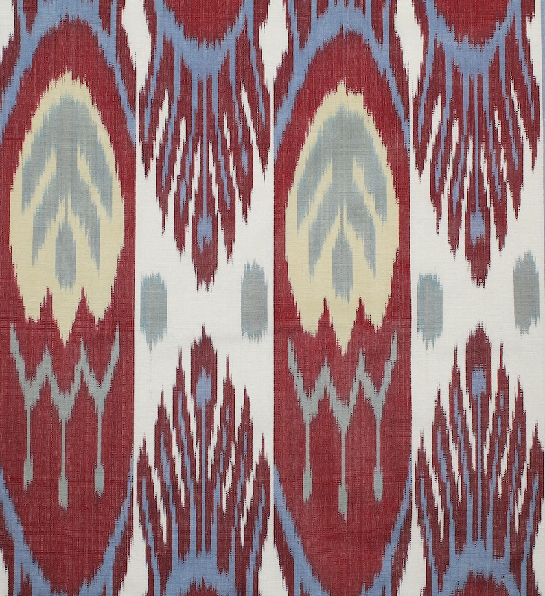 Pu&ograve; includere: Tessuto ikat rosso, blu e bianco con un motivo ripetitivo di fiori stilizzati. Il tessuto ha una trama tessuta e un aspetto leggermente usurato.