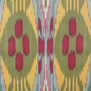 May include: A close-up of a fabric with a repeating pattern of red, yellow, green, and blue. The pattern is a traditional ikat design.