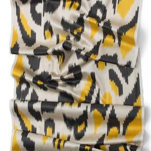 May include: A close-up of a fabric with a black and yellow animal print pattern. The fabric is a silky material and has a subtle sheen.