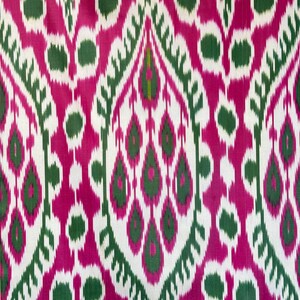 May include: A vibrant textile featuring a repeating pattern of stylized teardrop and oval shapes. The design incorporates shades of fuchsia, green, and white, creating a bold and eye-catching visual effect. The fabric's intricate pattern suggests it could be used for upholstery or apparel.