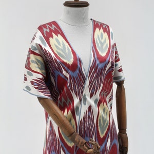 Pu&ograve; includere: Una veste di stile kimono con motivo rosso, blu e bianco con scollo a V. La veste &egrave; realizzata in tessuto setoso e ha una vestibilit&agrave; ampia.