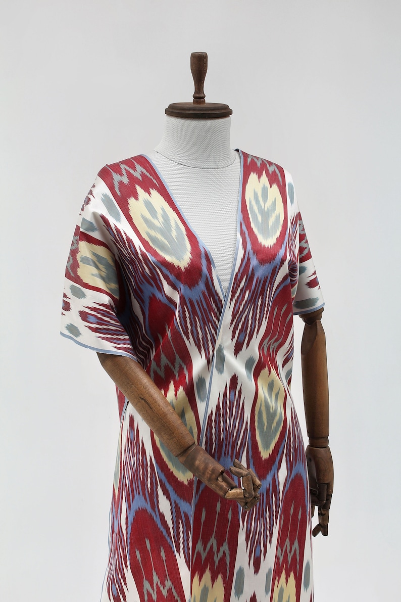 Pu&ograve; includere: Una veste di stile kimono con motivo rosso, blu e bianco con scollo a V. La veste &egrave; realizzata in tessuto setoso e ha una vestibilit&agrave; ampia.