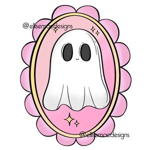 Puede incluir: Ilustraci&oacute;n de un fantasma de dibujos animados dentro de un marco ovalado rosa con un borde festoneado. El fantasma es blanco con ojos negros y una peque&ntilde;a sonrisa. El marco tiene un borde dorado y el texto "@ellissmaedesigns".