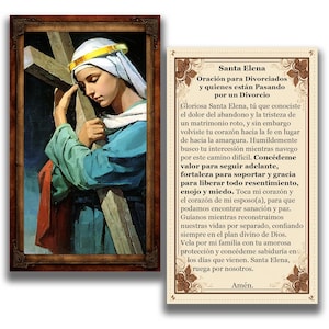 May include: A framed religious print featuring a woman in a white head covering and blue robe, holding a wooden cross. The print is accompanied by a card with text in Spanish, titled "Santa Elena" and a prayer for divorced individuals.