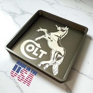 May include: Square olive green tray with a white rearing horse and the word "COLT" in white. The words "MADE IN THE USA" are printed on the bottom left with the American flag.