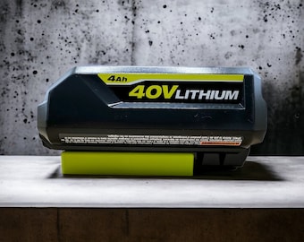 Batería Ryobi de 40 V con bloqueo para montaje en pared debajo de un estante, para garaje y taller