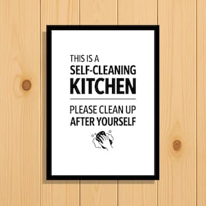 May include: A rectangular wall sign with a black frame and white background featuring the black text THIS IS A SELF-CLEANING KITCHEN PLEASE CLEAN UP AFTER YOURSELF and a small black icon of a hand holding a sponge with bubbles underneath.