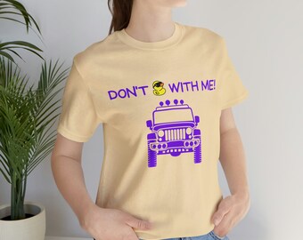 Peut inclure: Un t-shirt jaune clair avec une jeep violette et un canard en caoutchouc jaune avec des lunettes de soleil sur le dessus de la jeep. Le texte "DON'T  WITH ME!" est imprimé sur le t-shirt.