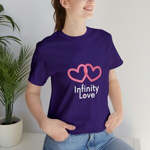 May include: A purple t-shirt with a pink infinity symbol made of two hearts and the text "Infinity Love" printed on the front.