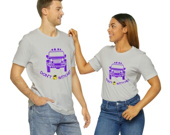 Peut inclure: Deux t-shirts gris avec un graphique de jeep violet et le texte "Ne vous mêlez pas de moi !" en violet. La jeep a un smiley jaune sur le devant.